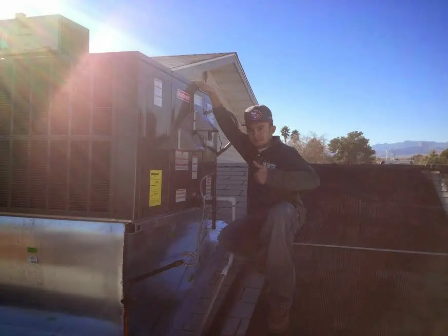 HVAC technician performing Heat Pump Repair on a rooftop unit in Norwalk